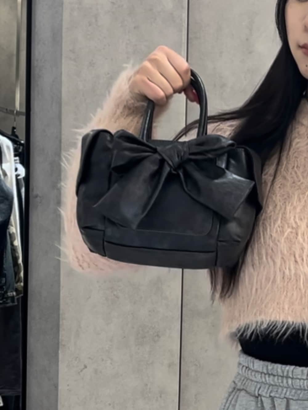 ピンク系のニット/セーター、グレー系のスウェットパンツ、ブラック系のハンドバッグを着用したレディースの冬コーディネートの7枚目の写真