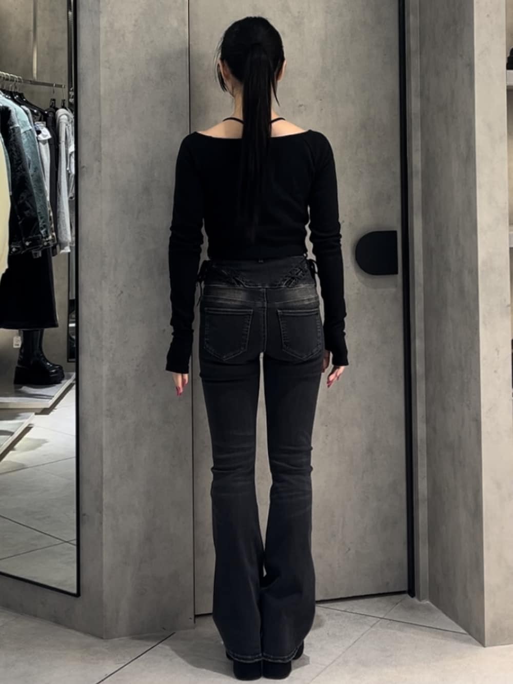 ブラック系のTシャツ/カットソー、ブラック系のデニムパンツ、ブラック系のブーツを着用したレディースの冬コーディネートの4枚目の写真