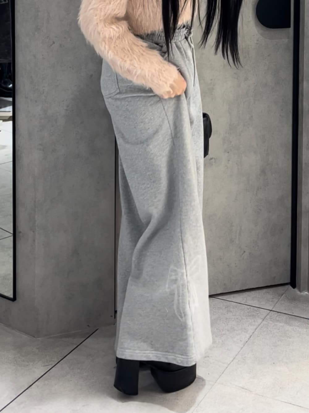 ピンク系のニット/セーター、グレー系のスウェットパンツ、ブラック系のハンドバッグを着用したレディースの冬コーディネートの5枚目の写真