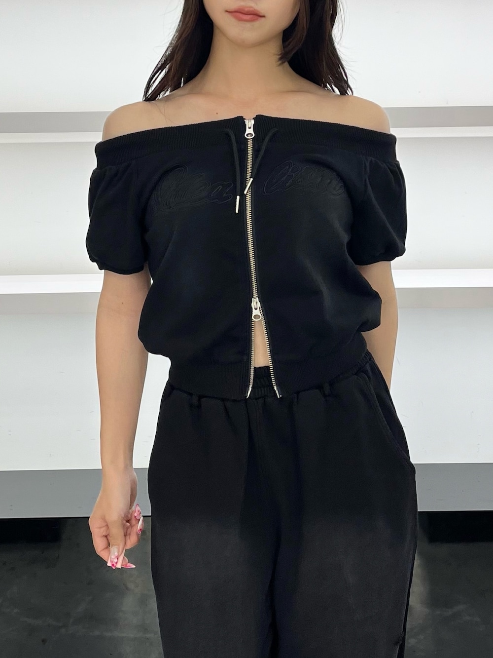 ブラック系のスウェット、ブラック系のスウェットパンツ、ブラック系のサンダルを着用したレディースの夏コーディネートの7枚目の写真