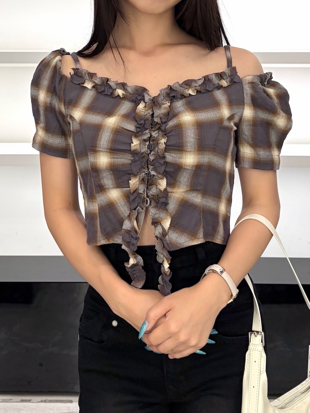 ブラウン系のTシャツ/カットソー、ホワイト系のハンドバッグ、ブラック系のデニムパンツを着用したレディースの夏コーディネートの7枚目の写真