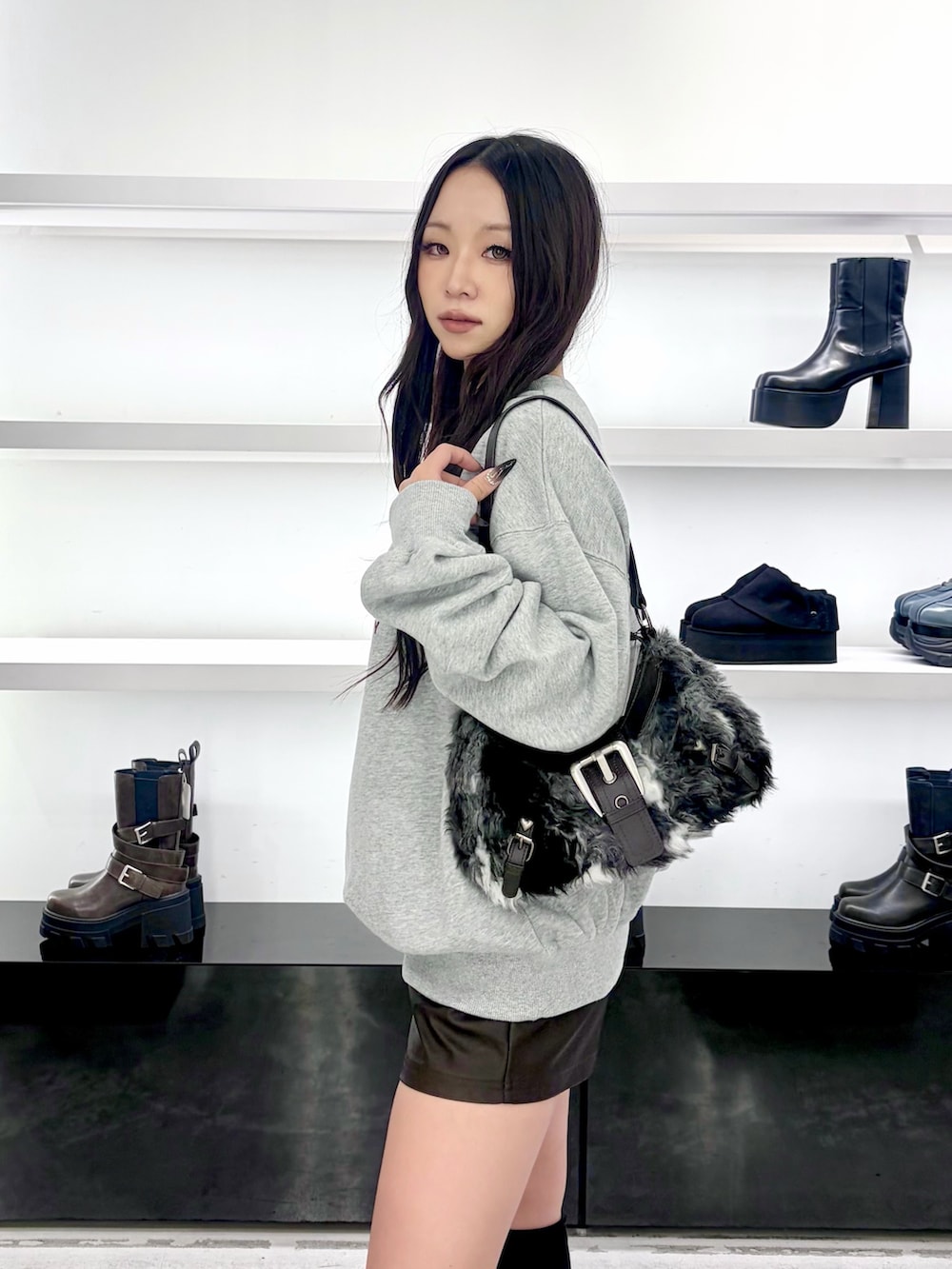 グレー系のスウェット、ブラウン系のその他パンツ、ブラック系のショルダーバッグを着用したレディースの秋コーディネートの7枚目の写真