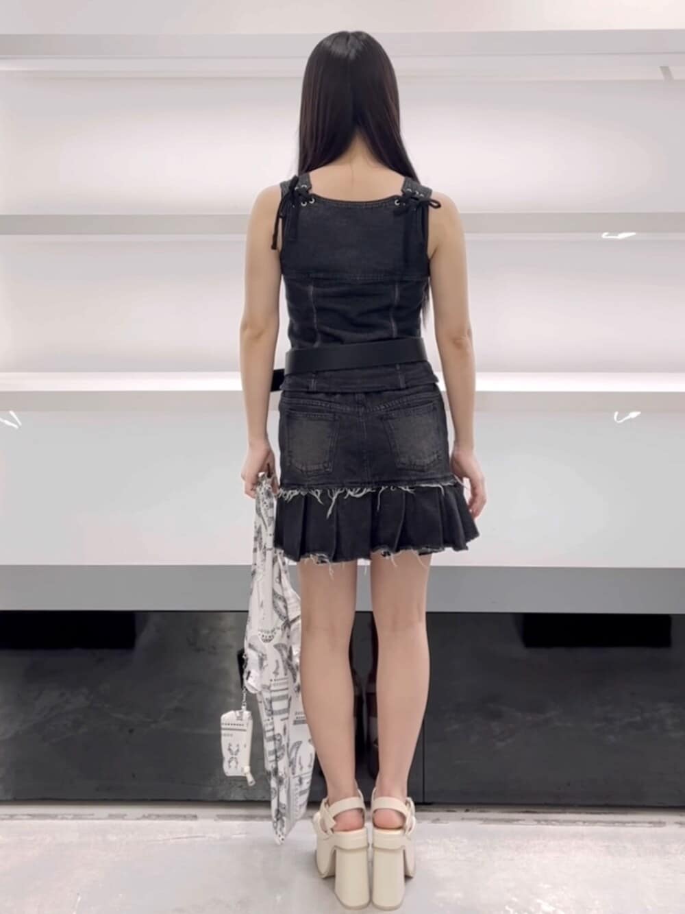 ホワイト系のサンダル、ホワイト系のトートバッグ、ブラック系のワンピースを着用したレディースの春コーディネートの4枚目の写真