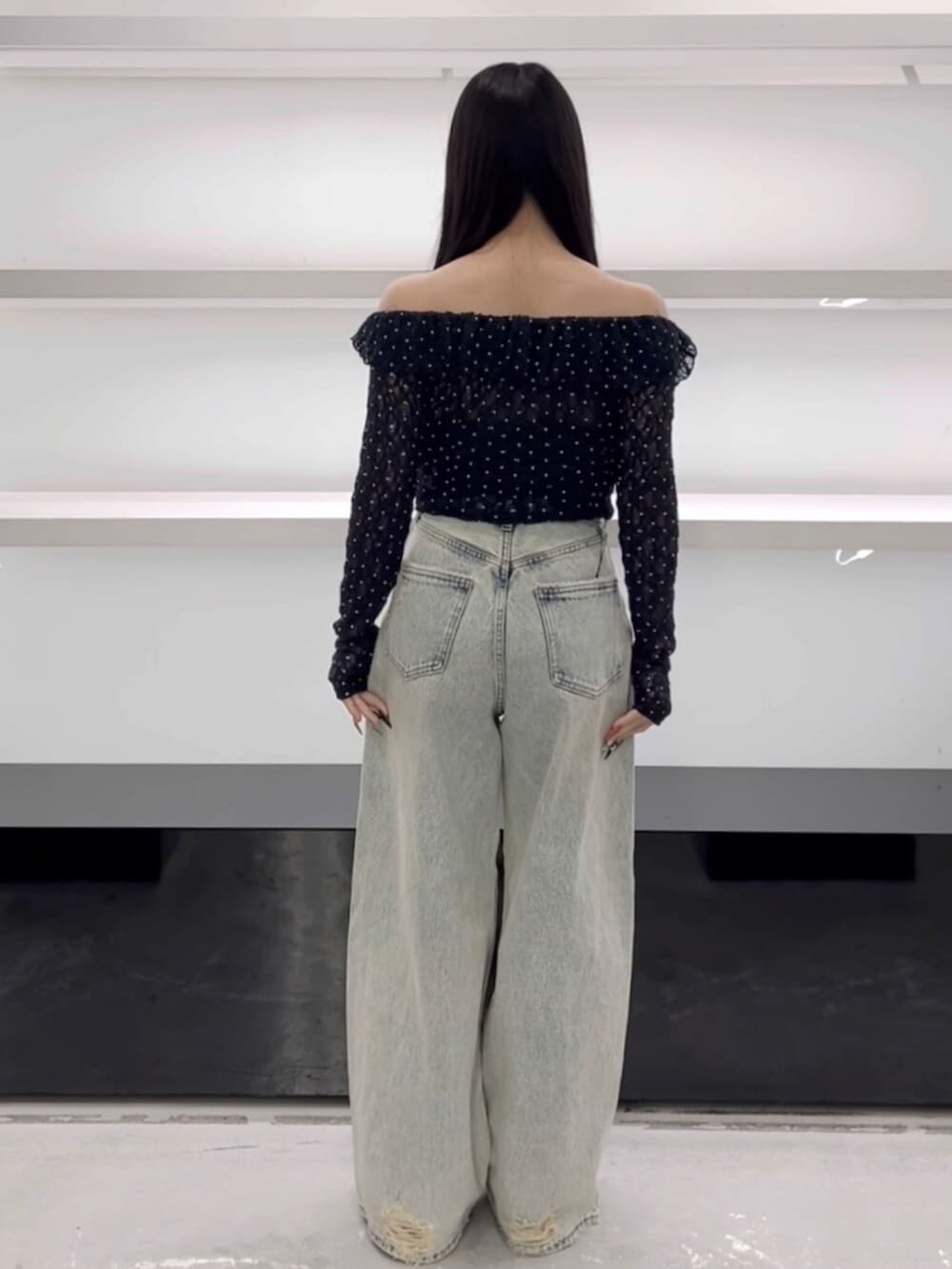 ブラック系のスニーカー、ブルー系のTシャツ/カットソー、ブルー系のデニムパンツを着用したレディースの春コーディネートの3枚目の写真