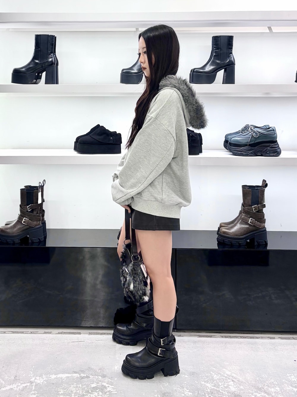 グレー系のパーカー、ブラック系のショルダーバッグ、ブラック系のその他パンツを着用したレディースの秋コーディネートの3枚目の写真