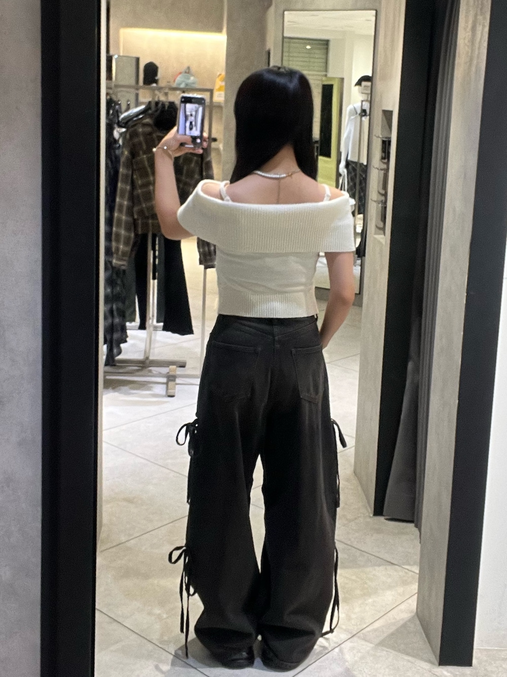 ホワイト系のニット/セーター、ブラック系のデニムパンツ、ブラック系のサンダルを着用したレディースの秋コーディネートの2枚目の写真