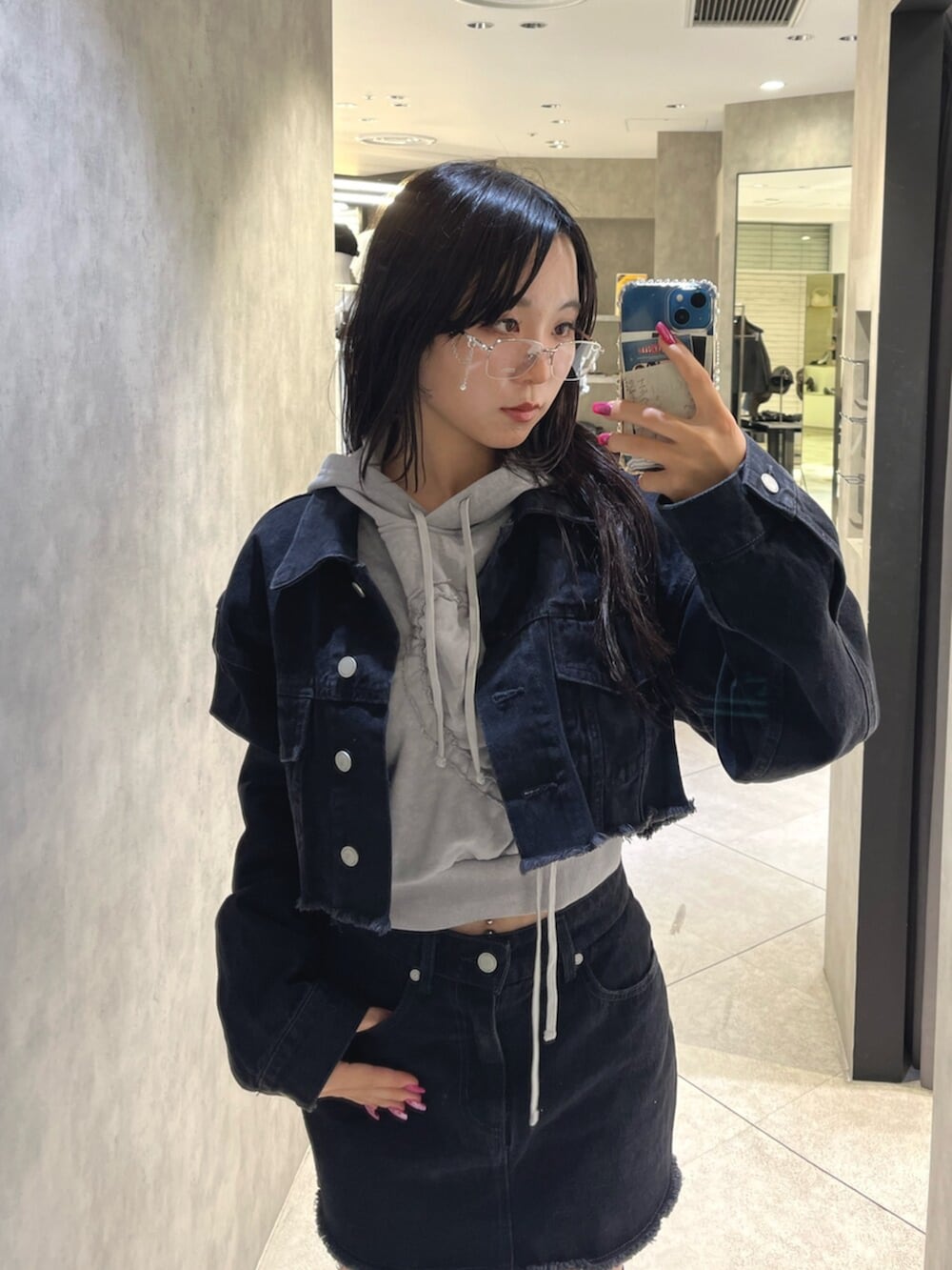 ブラック系のブーツ、グレー系のパーカー、ブラック系のスカートを着用したレディースの秋コーディネートの4枚目の写真