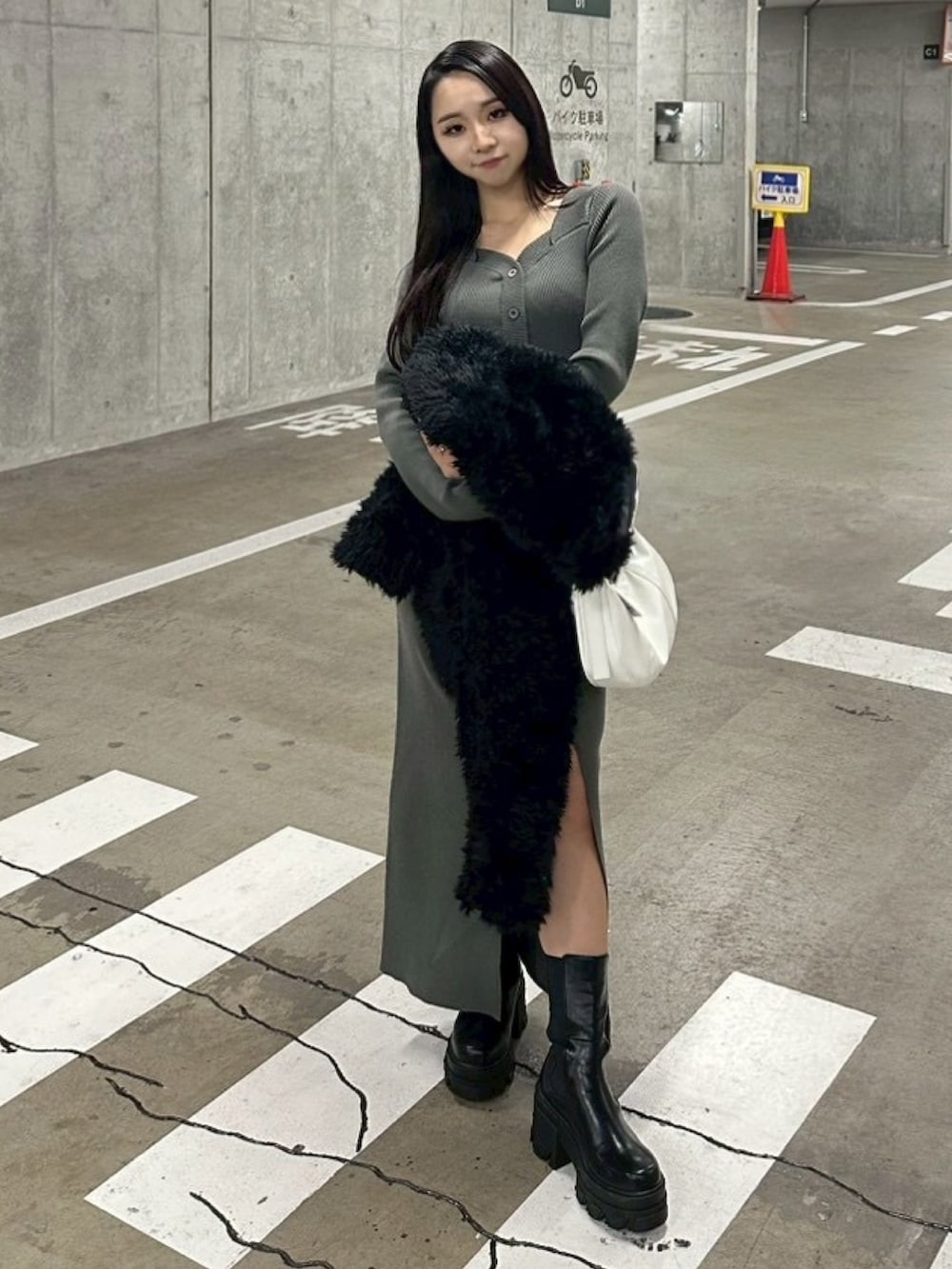 ブラック系のブルゾン、グレー系のワンピース、ホワイト系のショルダーバッグを着用したレディースの冬コーディネートの9枚目の写真