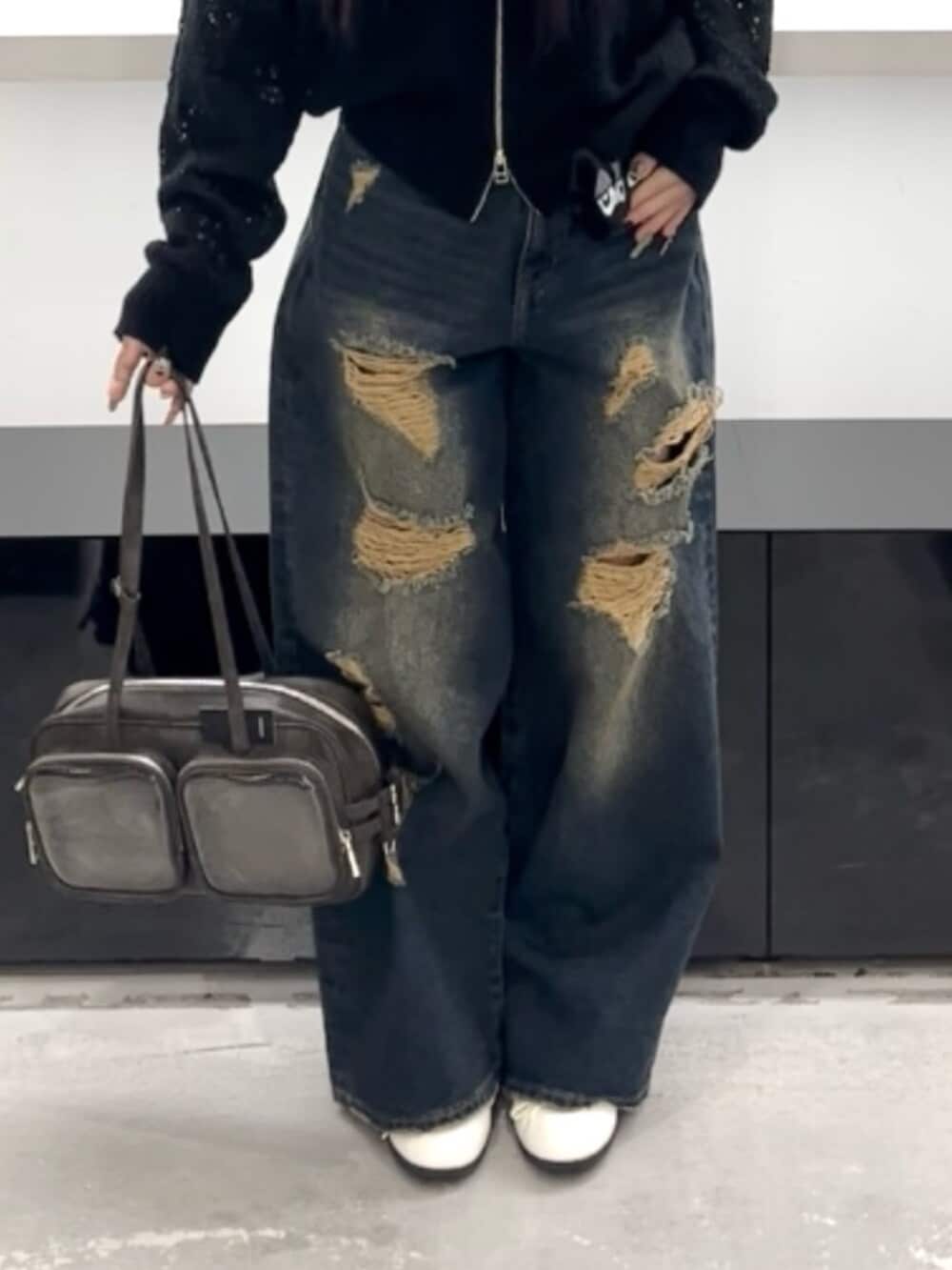 ホワイト系のスニーカー、ブルー系のデニムパンツ、ブラック系のパーカーを着用したレディースの春コーディネートの7枚目の写真