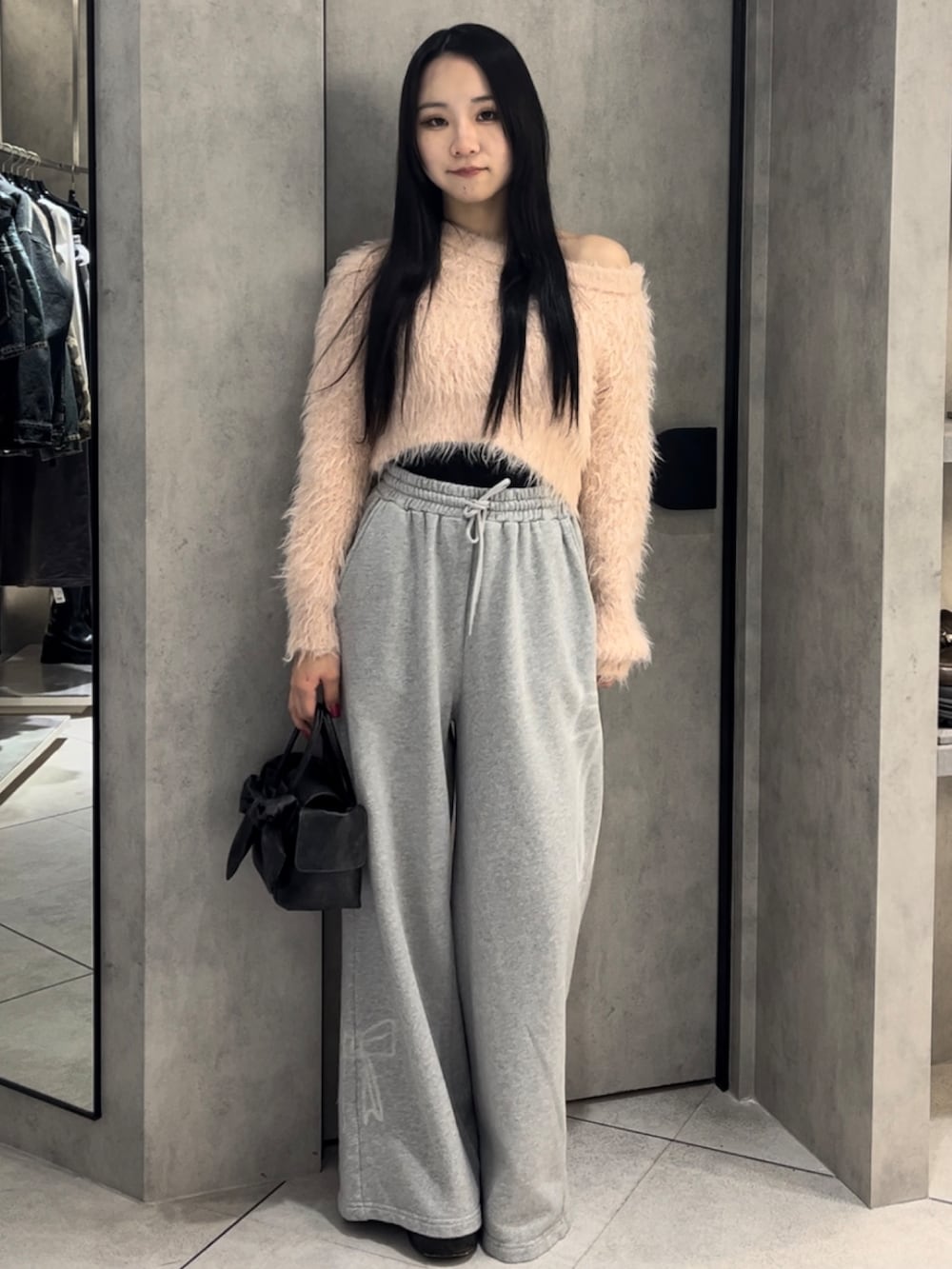 ピンク系のニット/セーター、グレー系のスウェットパンツ、ブラック系のハンドバッグを着用したレディースの冬コーディネートの8枚目の写真