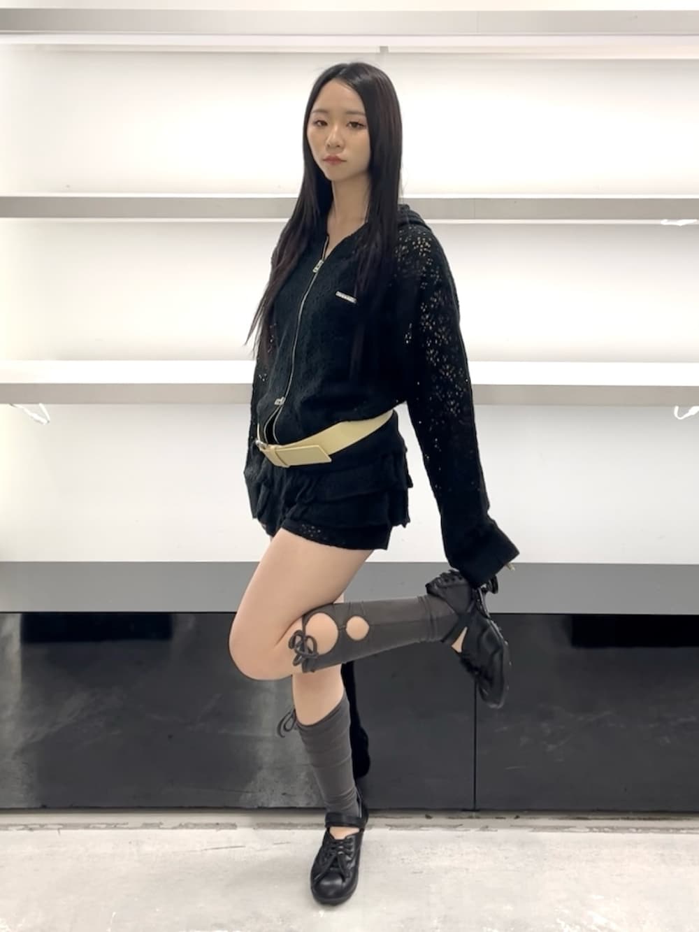 ブラック系のパーカー、ブラック系のスカート、ブラック系のスニーカーを着用したレディースの春コーディネートの7枚目の写真