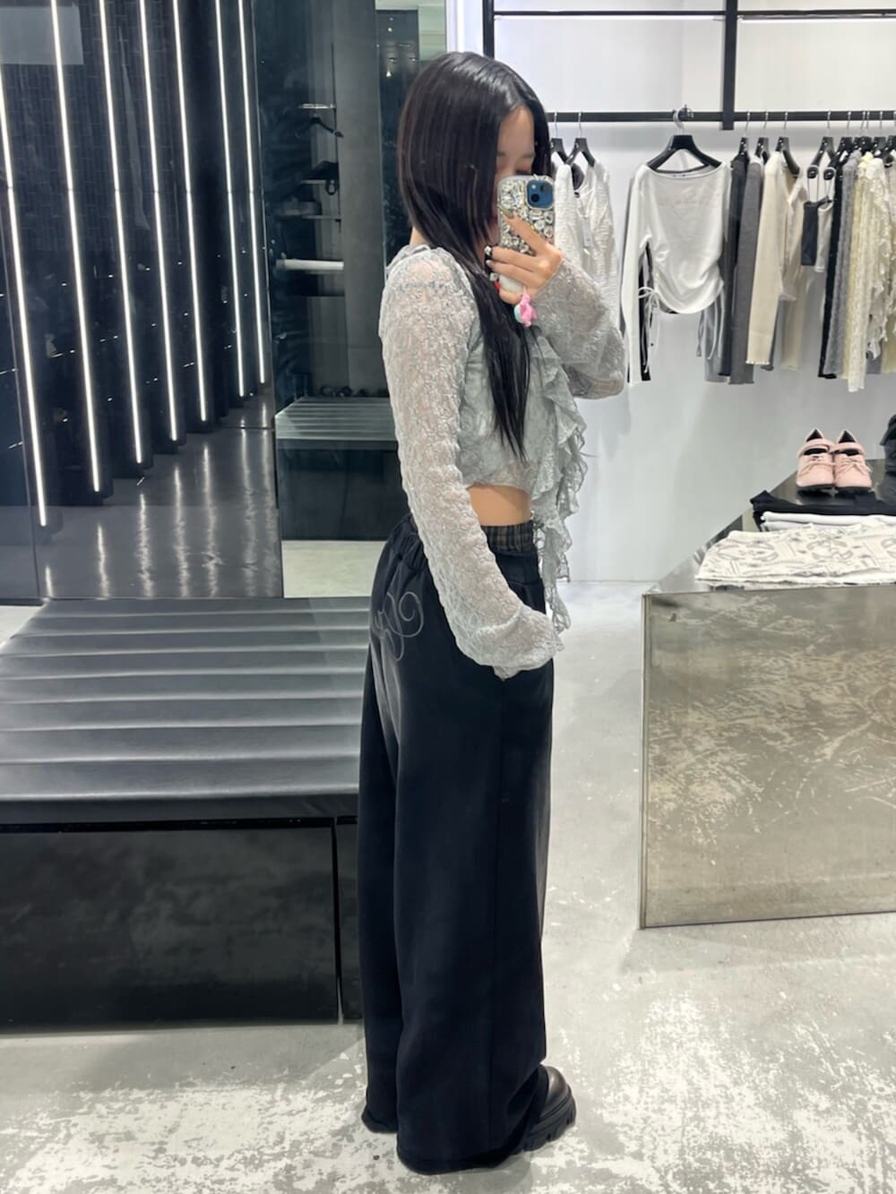 グレー系のTシャツ/カットソー、ブラック系のスウェットパンツ、ホワイト系のニット/セーターを着用したレディースの春コーディネートの2枚目の写真