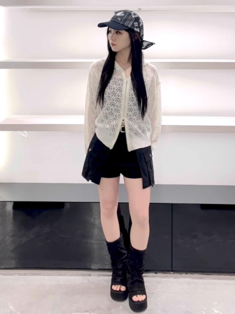 ブラック系のサンダル、ホワイト系のパーカー、ブラック系のスカートを着用したレディースの春コーディネートの9枚目の写真