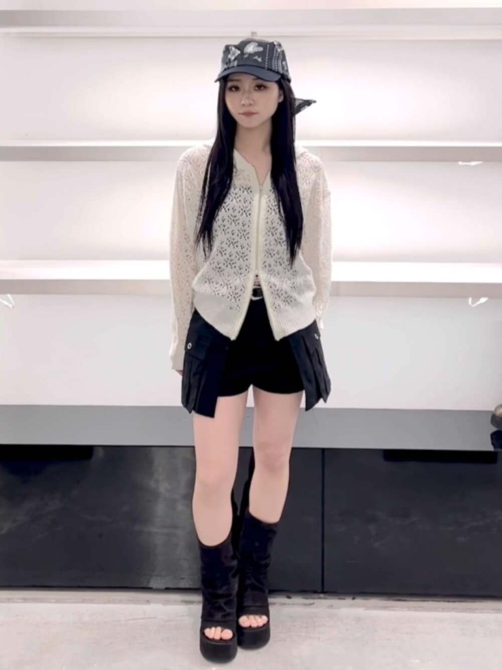 ブラック系のサンダル、ホワイト系のパーカー、ブラック系のスカートを着用したレディースの春コーディネートの2枚目の写真