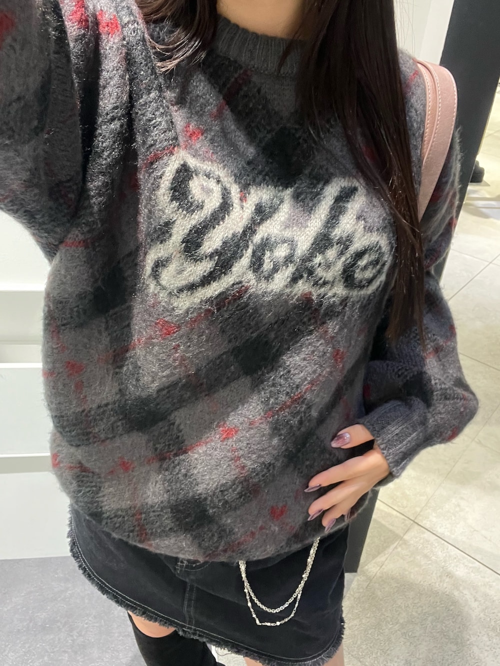 ブラック系のスカート、ピンク系のハンドバッグ、グレー系のニット/セーターを着用したレディースの秋コーディネートの9枚目の写真