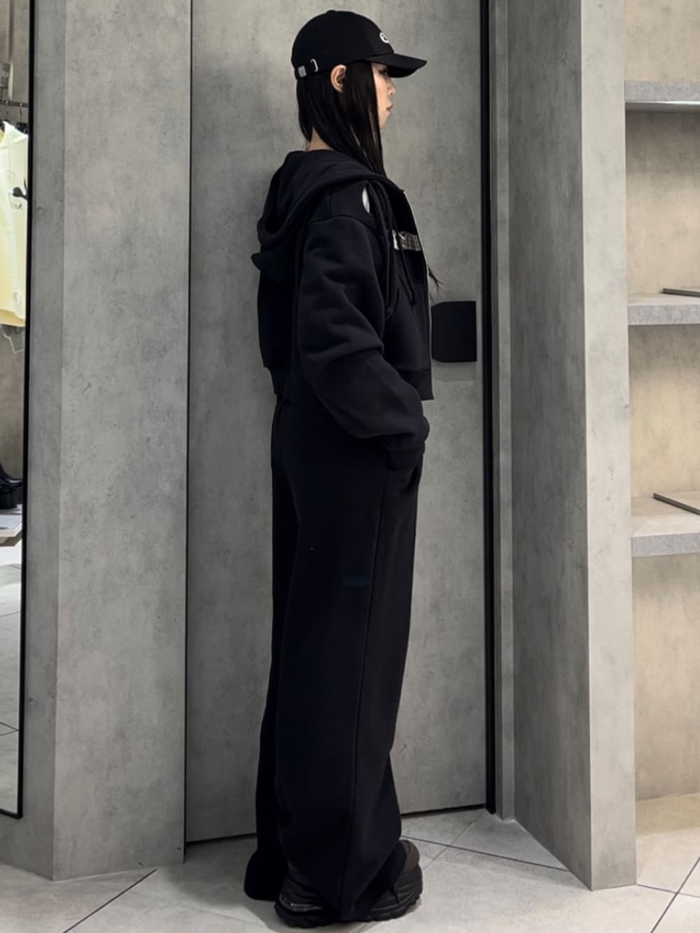 ホワイト系のニット/セーター、ブラック系のパーカー、ブラック系のスウェットパンツを着用したレディースの冬コーディネートの2枚目の写真