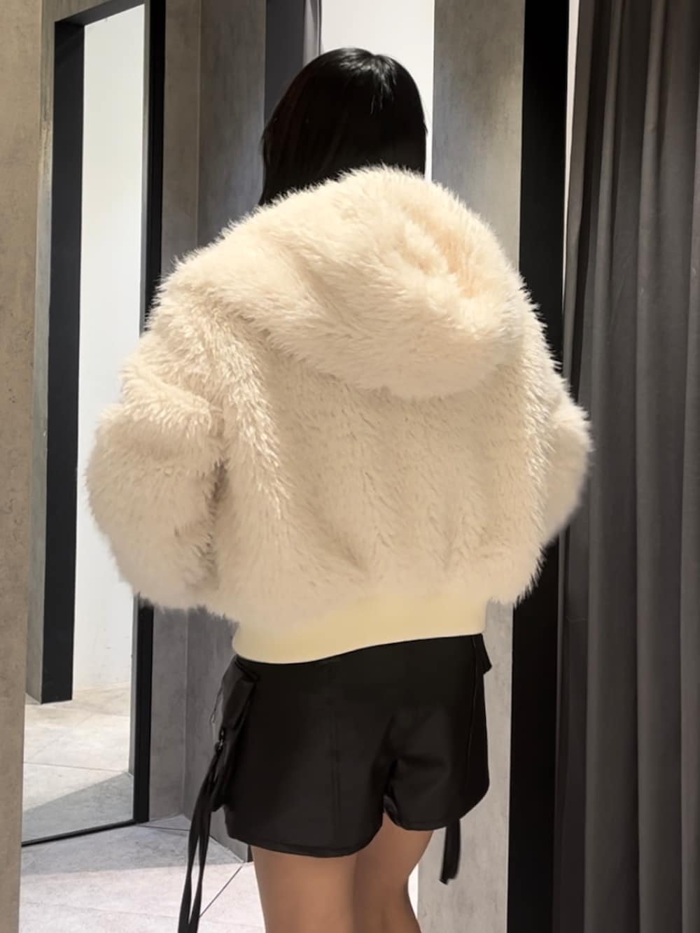 ホワイト系のブルゾン、ブルー系のニット/セーター、ブラック系のその他パンツを着用したレディースの冬コーディネートの7枚目の写真