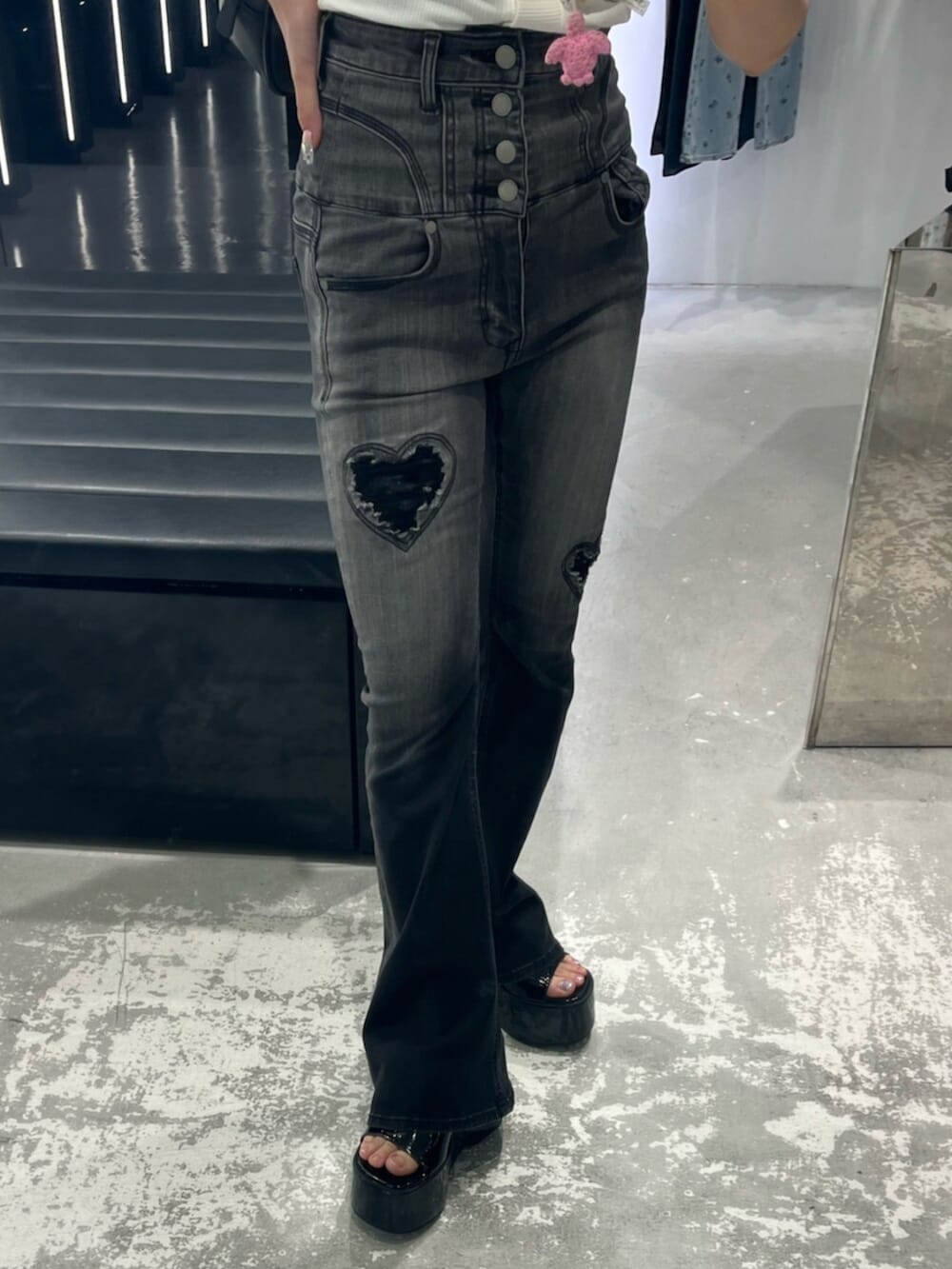 ブラック系のデニムパンツ、ブラック系のサンダル、ホワイト系のTシャツ/カットソーを着用したレディースの春コーディネートの6枚目の写真
