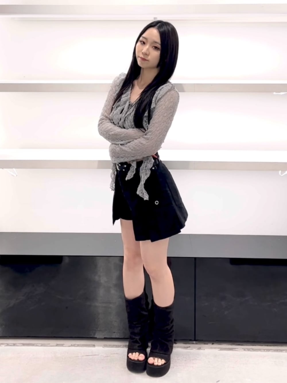 グレー系のTシャツ/カットソー、ブラック系のスカート、ブラック系のサンダルを着用したレディースの春コーディネートの6枚目の写真