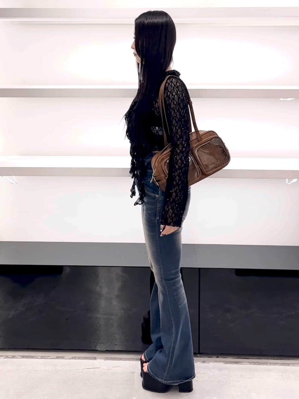 ブラック系のTシャツ/カットソー、ブルー系のデニムパンツ、ブラウン系のショルダーバッグを着用したレディースの春コーディネートの3枚目の写真