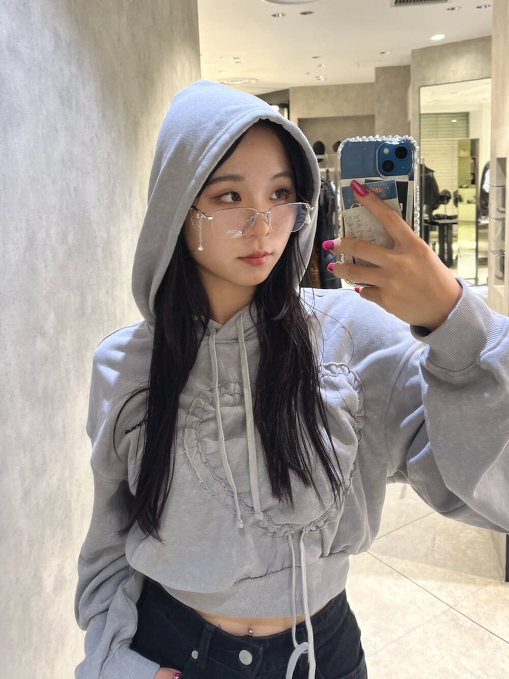 ブラック系のブーツ、グレー系のパーカー、ブラック系のスカートを着用したレディースの秋コーディネートの5枚目の写真