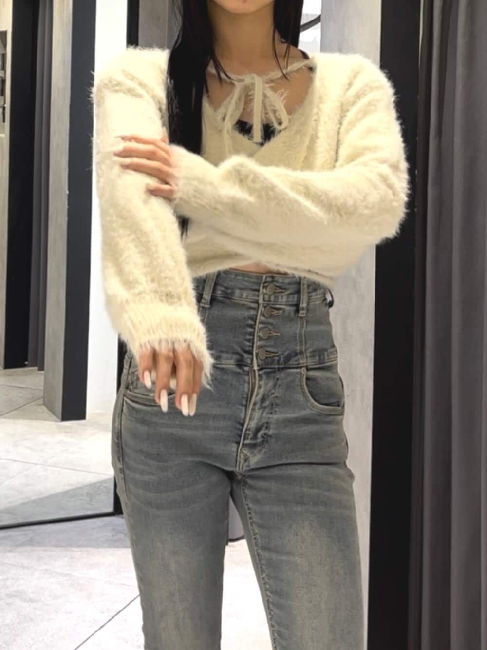 ブルー系のデニムパンツ、ホワイト系のニット/セーター、ブラック系のブーツを着用したレディースの冬コーディネートの5枚目の写真