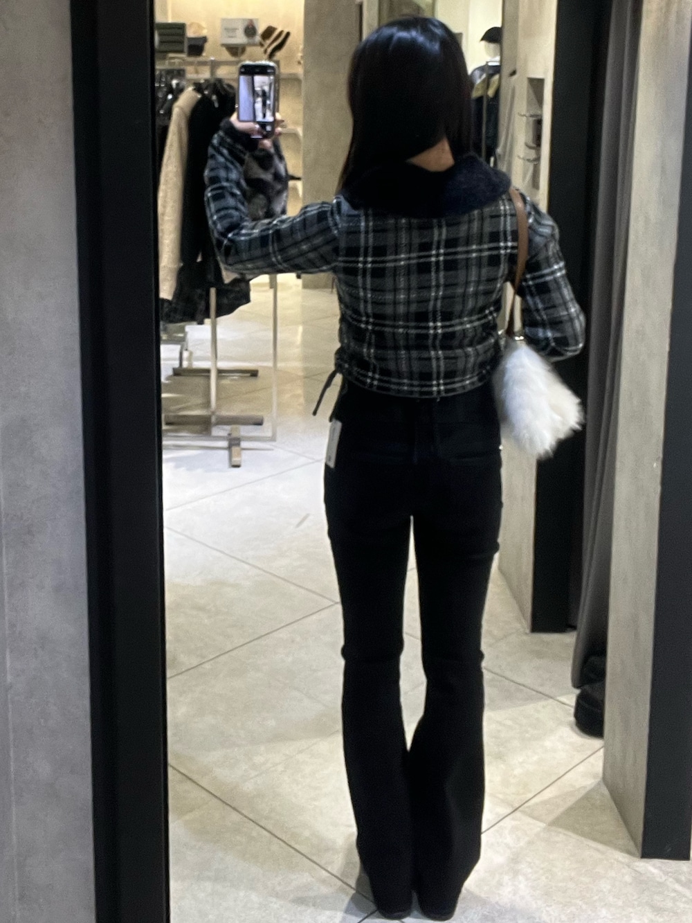 ブラック系のニット/セーター、ブラック系のデニムパンツ、ブラック系のブーツを着用したレディースの冬コーディネートの3枚目の写真