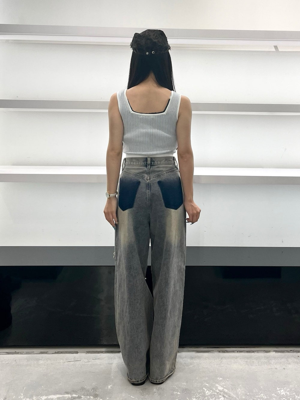 ブルー系のデニムパンツ、ブラック系のサンダル、ブラウン系のハンチング/ベレー帽を着用したレディースの夏コーディネートの4枚目の写真