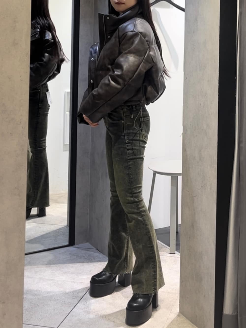 ブラウン系のダウンジャケット/コート、ホワイト系のニット/セーター、ブルー系のデニムパンツを着用したレディースの冬コーディネートの2枚目の写真