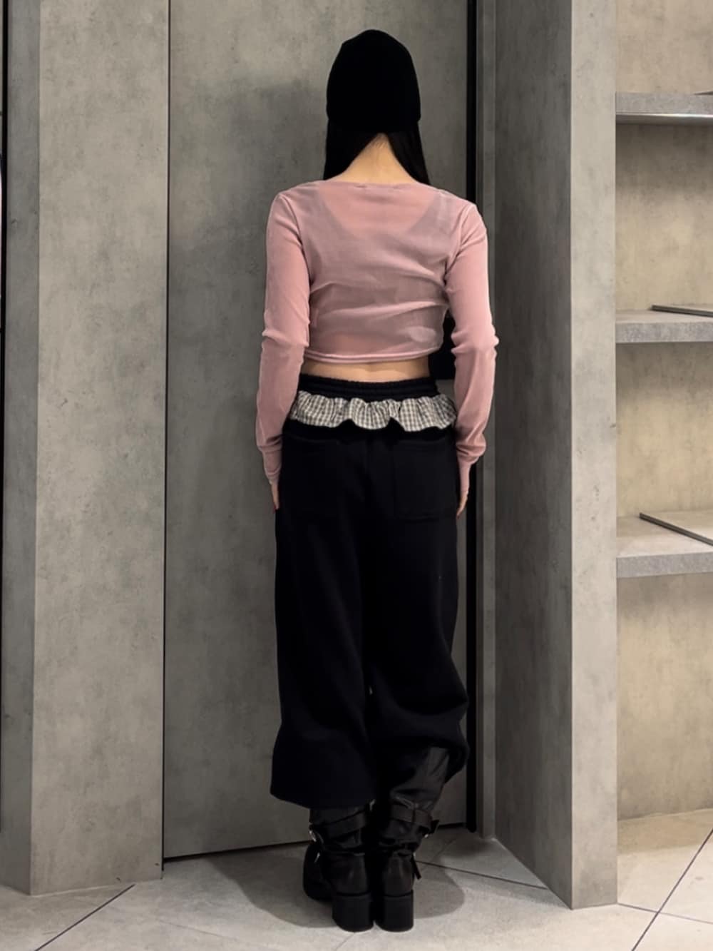 ピンク系のTシャツ/カットソー、ブラック系のスウェットパンツ、ブラック系のブーツを着用したレディースの冬コーディネートの3枚目の写真