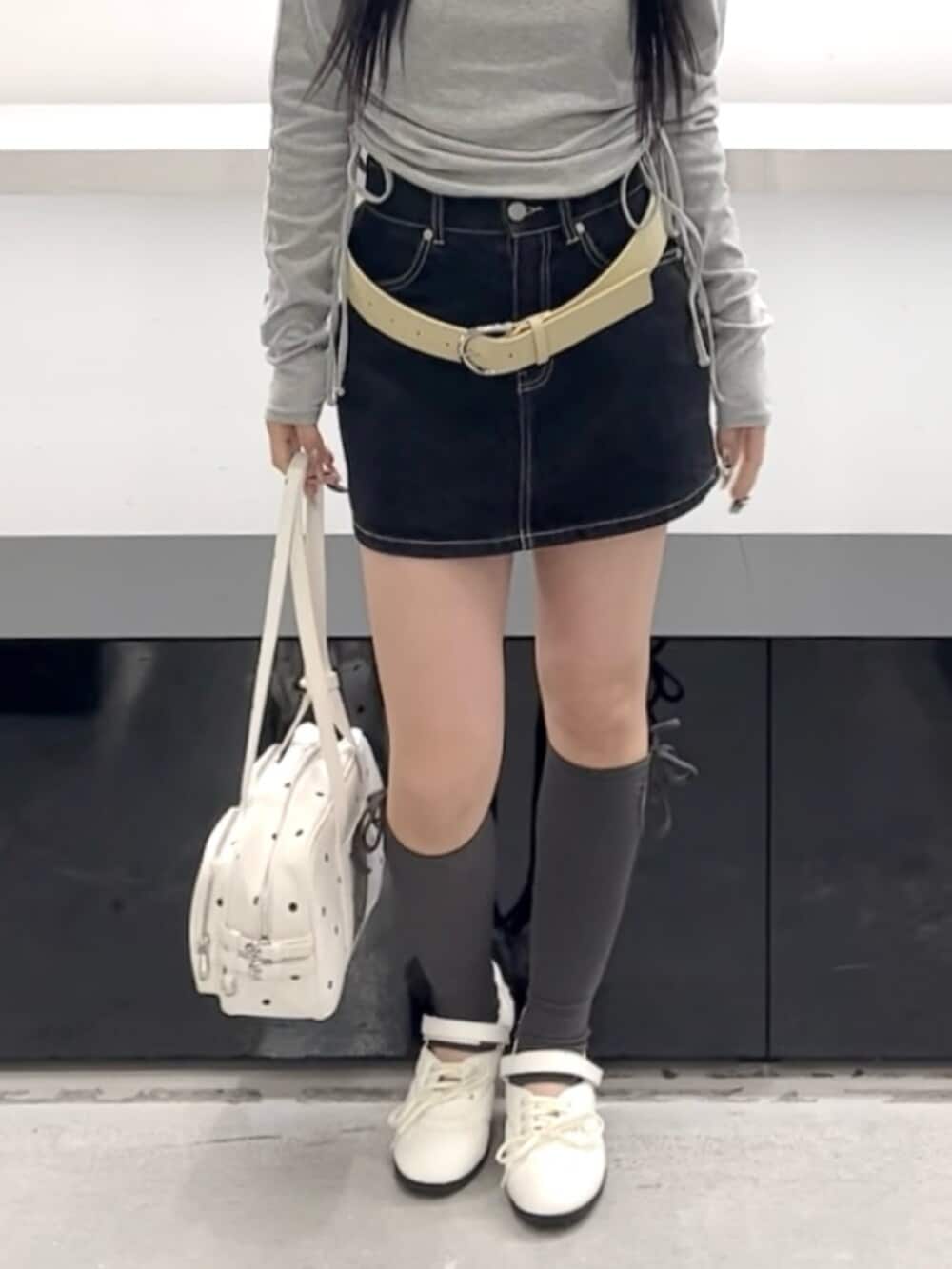 ブルー系のスカート、グレー系のTシャツ/カットソー、ホワイト系のショルダーバッグを着用したレディースの春コーディネートの9枚目の写真