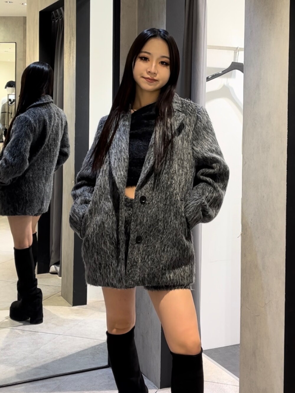 グレー系のその他アウター、ブラック系のニット/セーター、グレー系のその他パンツを着用したレディースの冬コーディネートの7枚目の写真