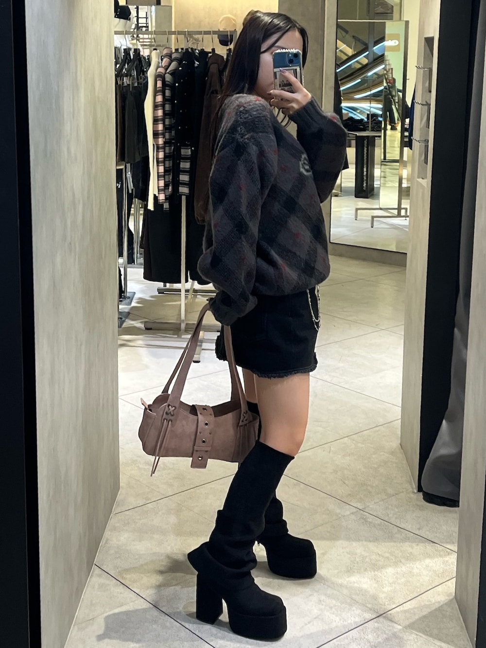 ブラック系のスカート、ピンク系のハンドバッグ、グレー系のニット/セーターを着用したレディースの秋コーディネートの2枚目の写真