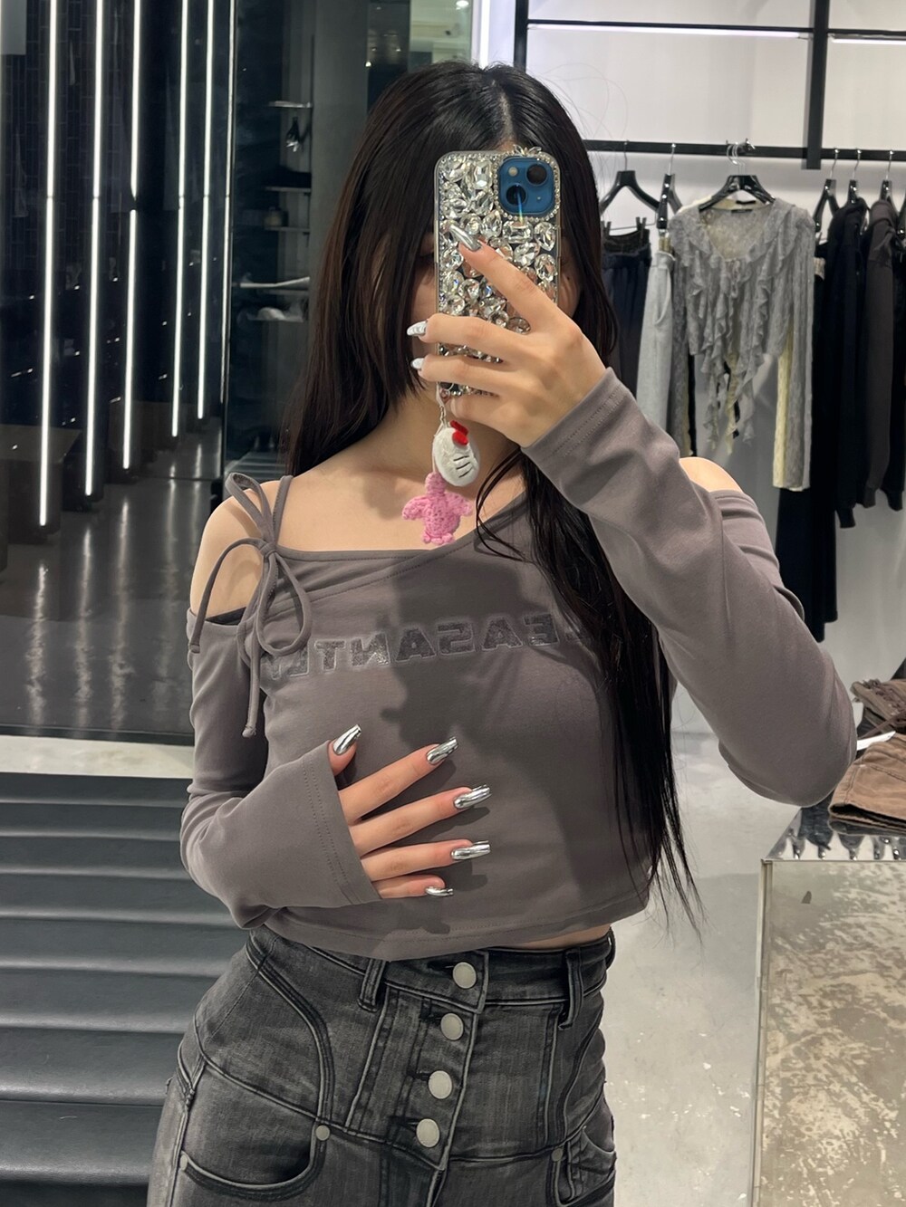 グレー系のTシャツ/カットソー、ブラック系のデニムパンツ、ブラック系のサンダルを着用したレディースの春コーディネートの5枚目の写真