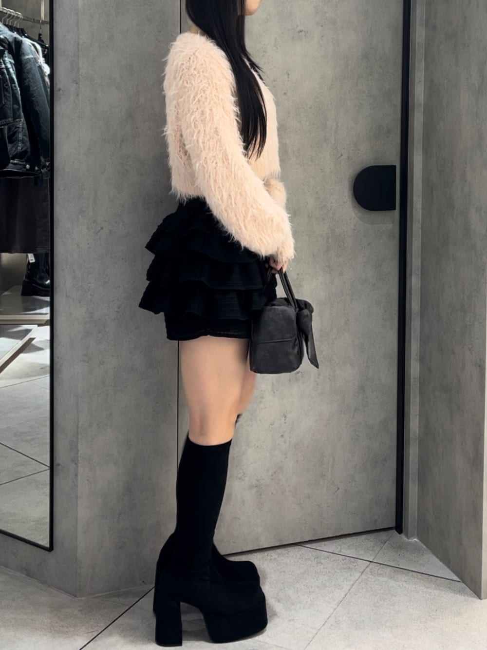 ピンク系のニット/セーター、ブラック系のハンドバッグ、ブラック系のその他パンツを着用したレディースの冬コーディネートの3枚目の写真