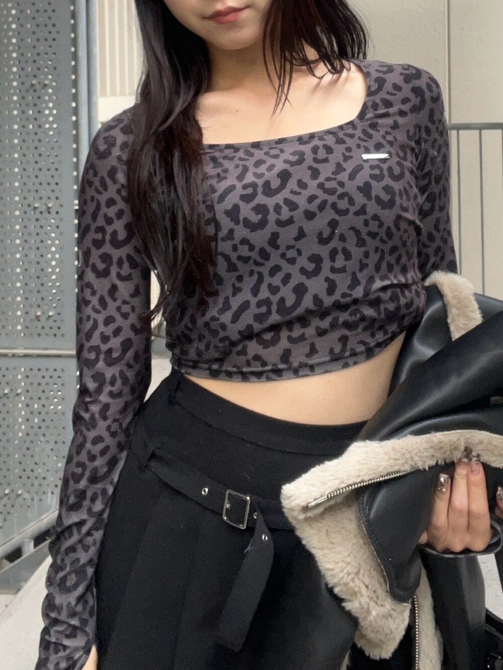 ブラック系のショルダーバッグ、ブラック系のブーツ、ブラック系のスカートを着用したレディースの秋コーディネートの7枚目の写真