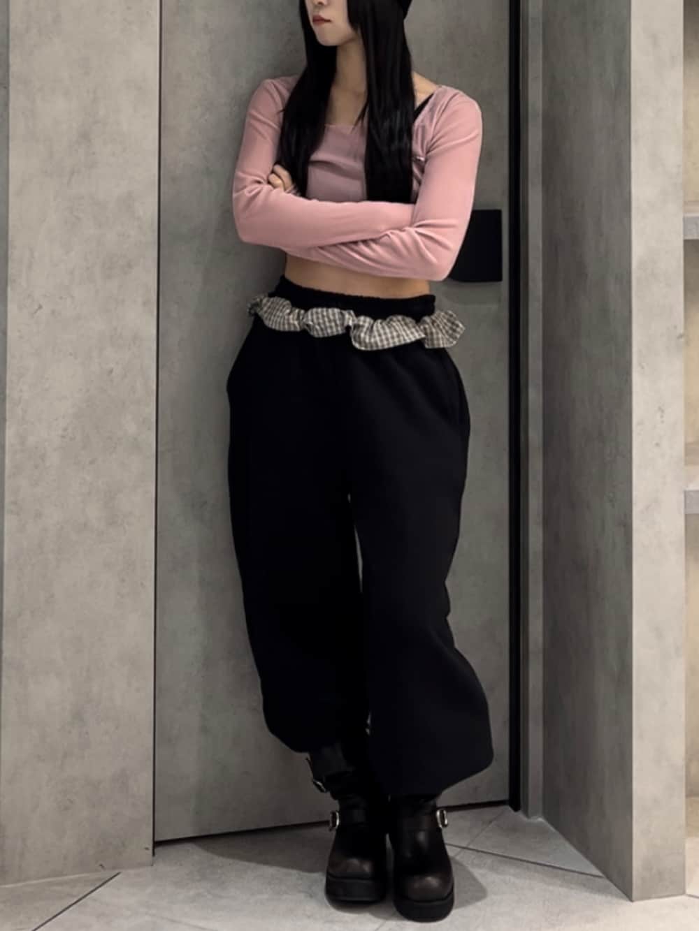 ピンク系のTシャツ/カットソー、ブラック系のスウェットパンツ、ブラック系のブーツを着用したレディースの冬コーディネートの6枚目の写真