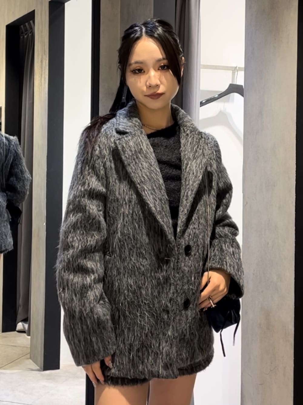 グレー系のその他アウター、ブラック系のニット/セーター、グレー系のその他パンツを着用したレディースの冬コーディネートの4枚目の写真