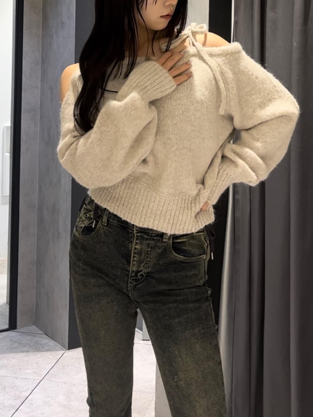 ブラウン系のダウンジャケット/コート、ホワイト系のニット/セーター、ブルー系のデニムパンツを着用したレディースの冬コーディネートの7枚目の写真