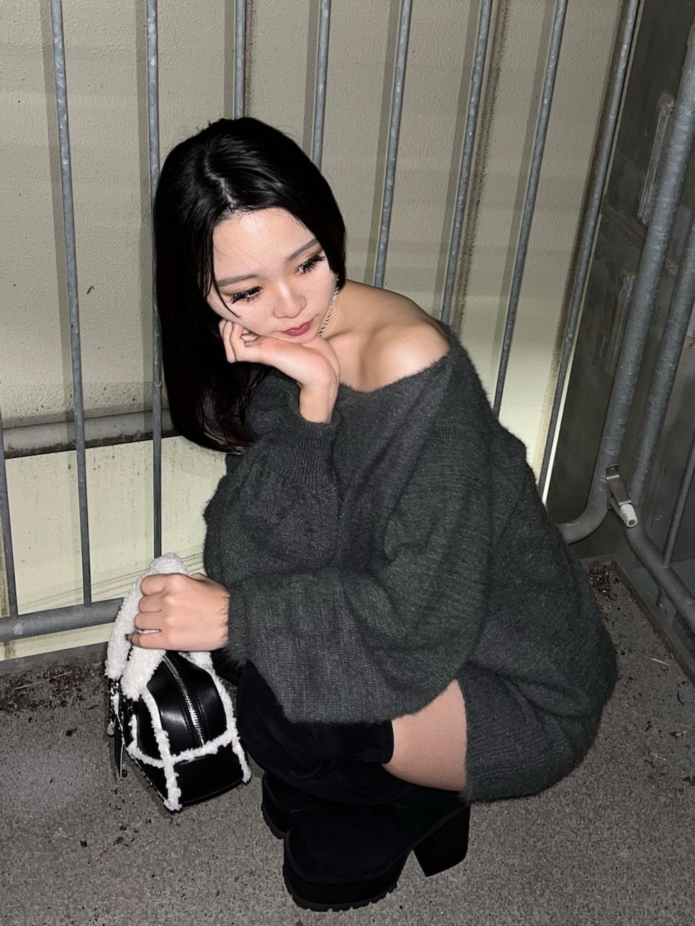 ブラック系のブルゾン、グレー系のワンピース、ブラック系のハンドバッグを着用したレディースの冬コーディネートの7枚目の写真