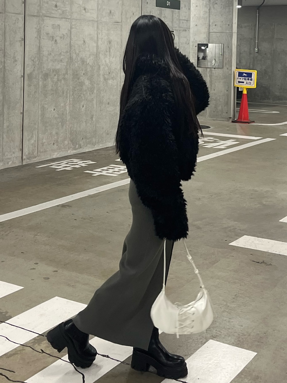 ブラック系のブルゾン、グレー系のワンピース、ホワイト系のショルダーバッグを着用したレディースの冬コーディネートの3枚目の写真