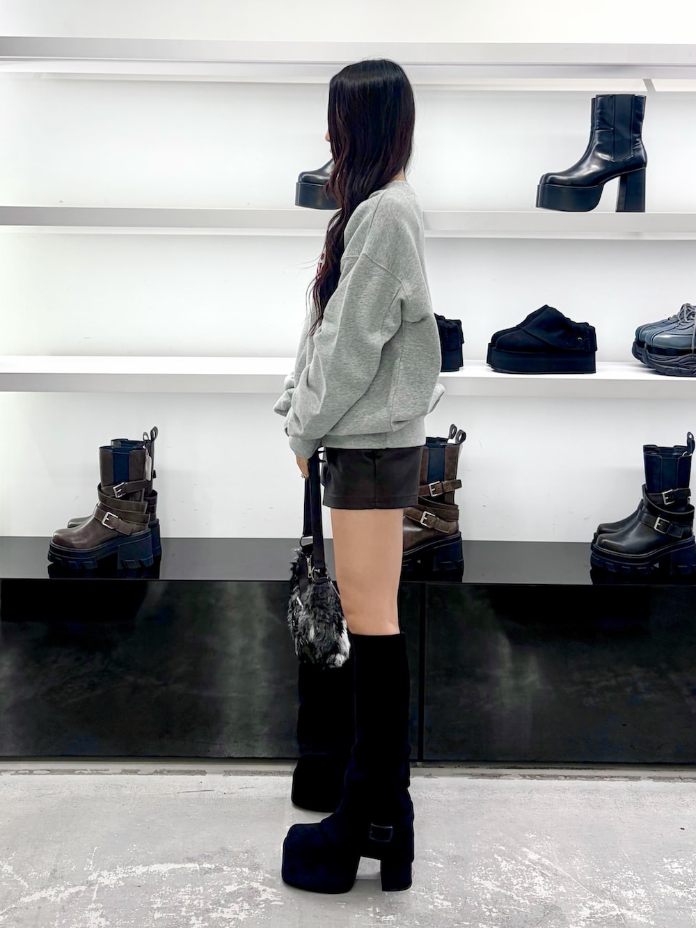グレー系のスウェット、ブラウン系のその他パンツ、ブラック系のショルダーバッグを着用したレディースの秋コーディネートの3枚目の写真