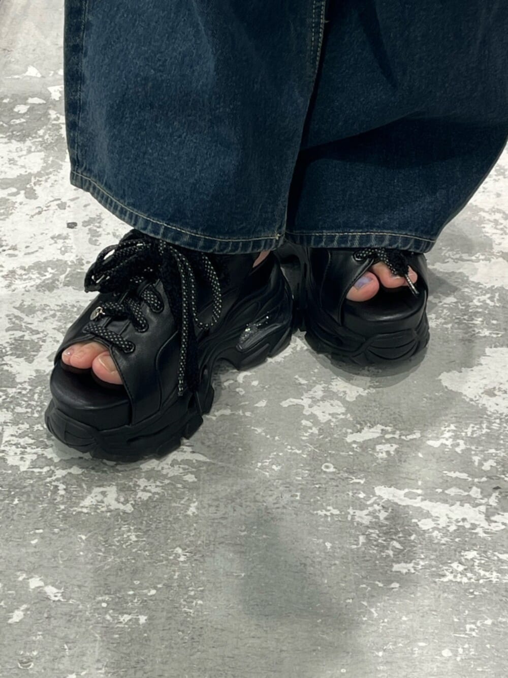 ブルー系のデニムパンツ、グレー系のニット/セーター、ブラック系のサンダルを着用したレディースの春コーディネートの7枚目の写真
