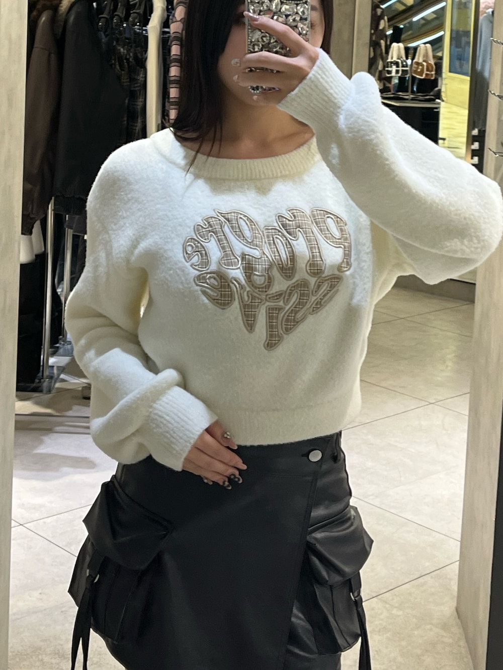 ホワイト系のニット/セーター、ブラック系のその他パンツ、ブラック系のブーツを着用したレディースの冬コーディネートの5枚目の写真