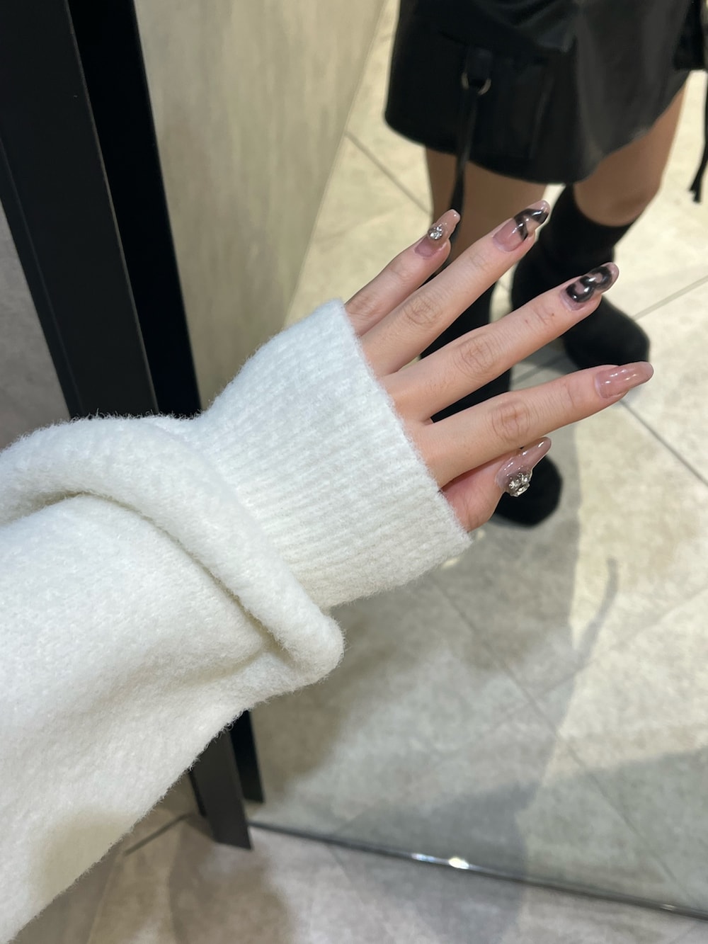 ホワイト系のニット/セーター、ブラック系のその他パンツ、ブラック系のブーツを着用したレディースの冬コーディネートの10枚目の写真