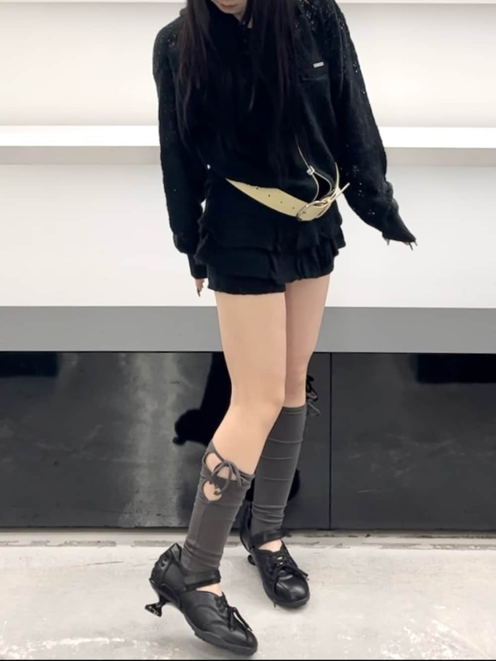 ブラック系のパーカー、ブラック系のスカート、ブラック系のスニーカーを着用したレディースの春コーディネートの8枚目の写真