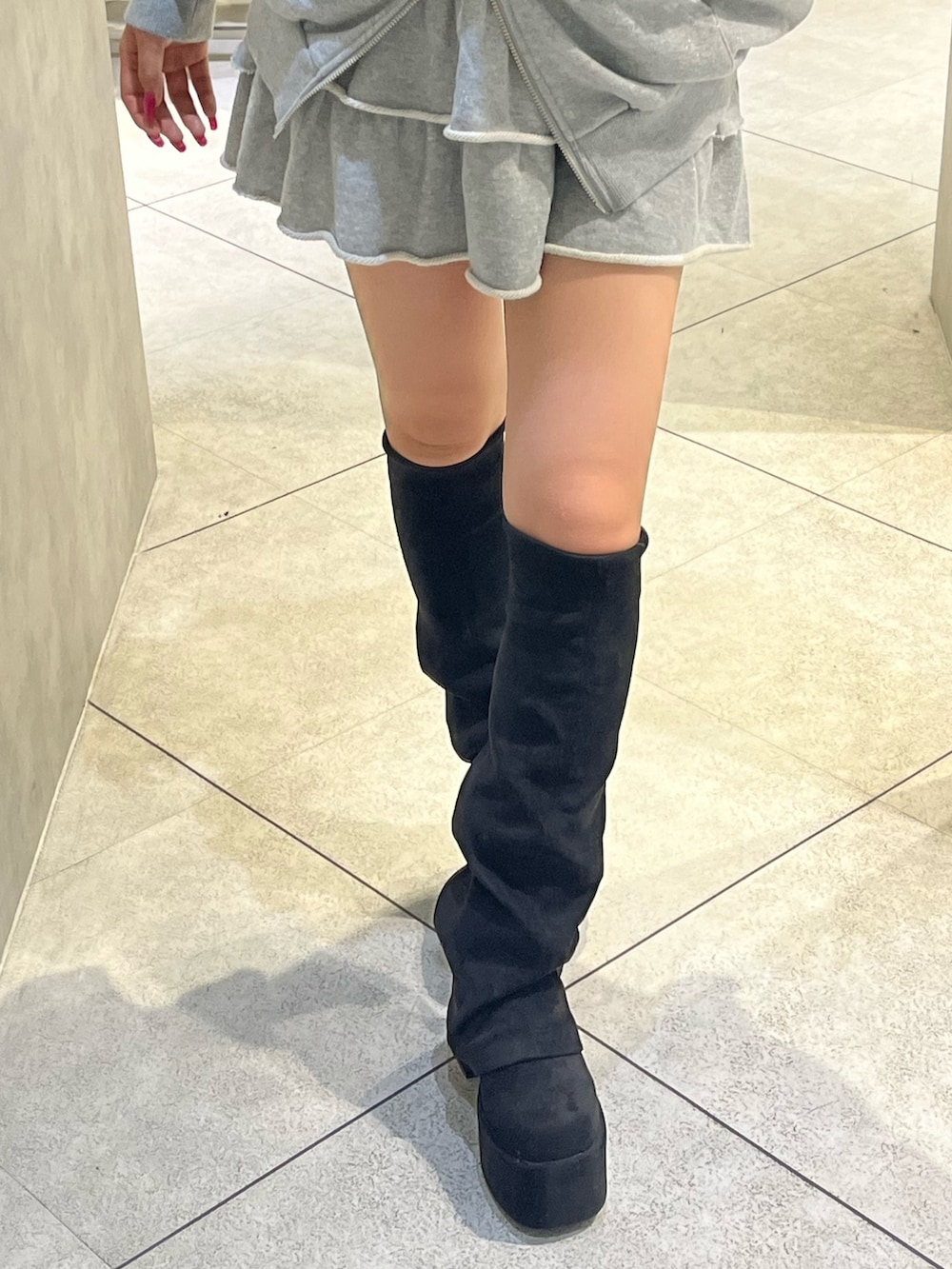 グレー系のパーカー、グレー系のスカート、ブラック系のショルダーバッグを着用したレディースの秋コーディネートの8枚目の写真
