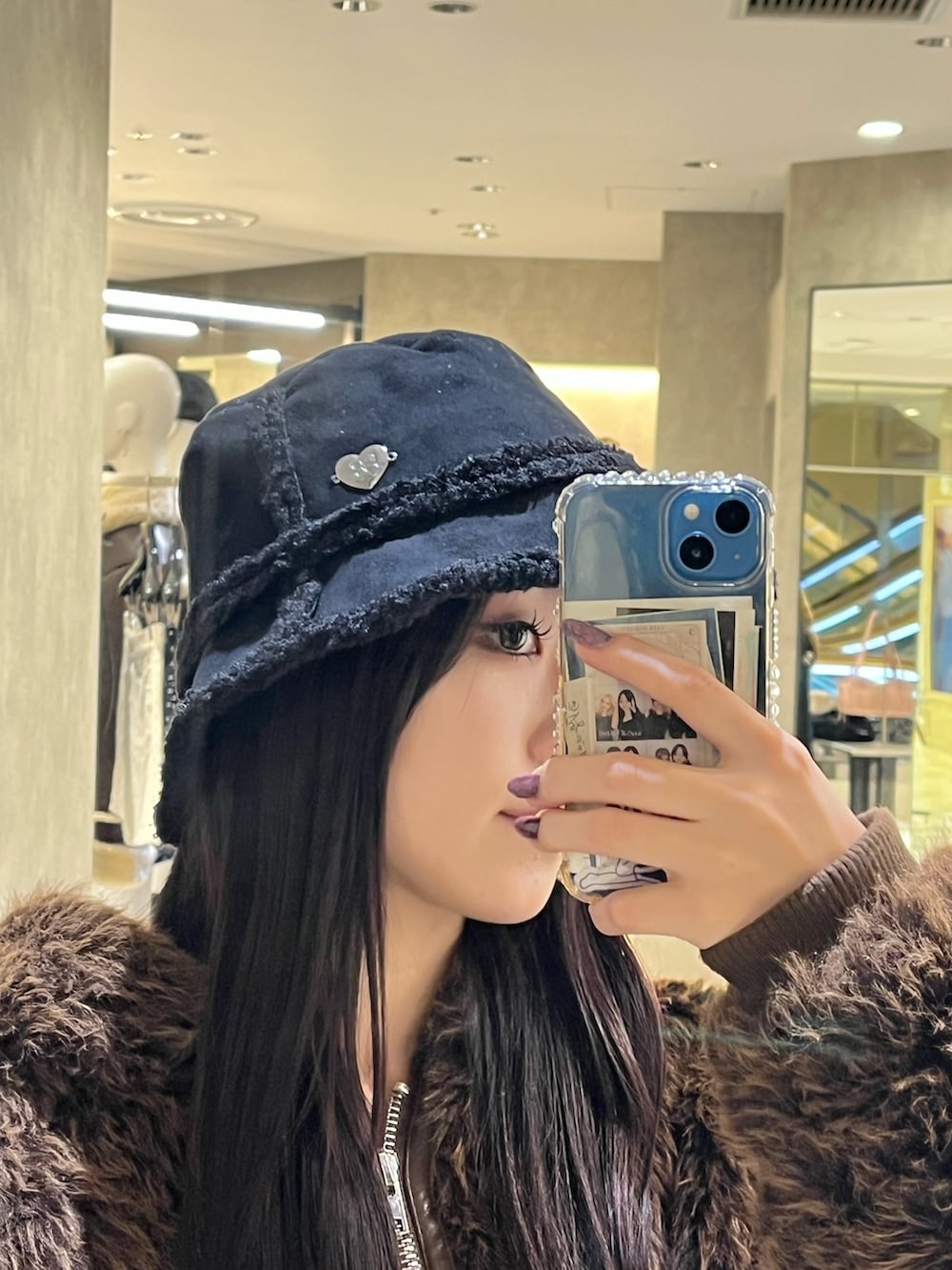 ブラック系のブーツ、ブラック系のハンドバッグ、ブルー系のスカートを着用したレディースの秋コーディネートの7枚目の写真