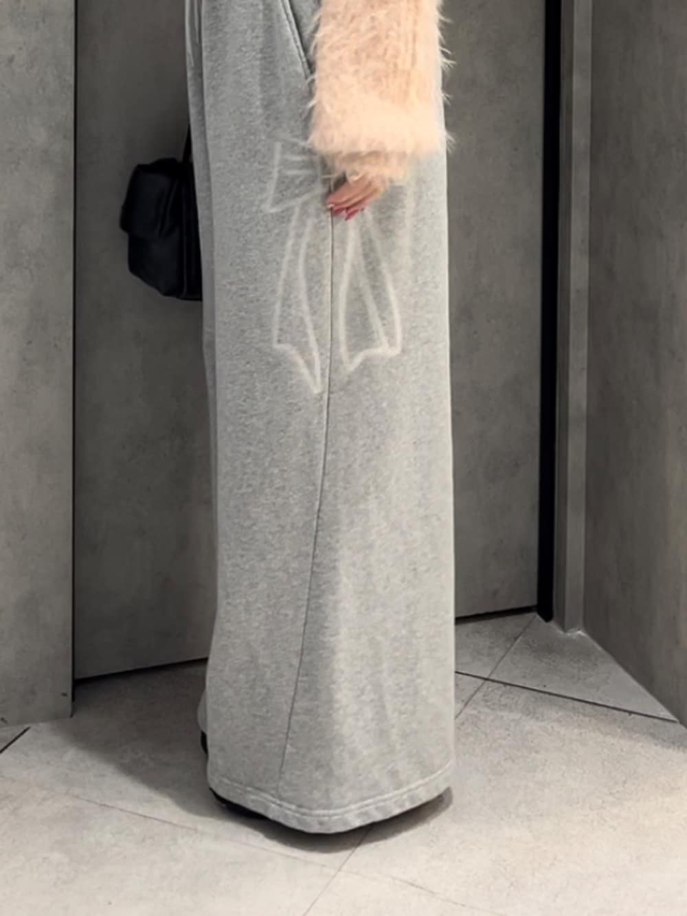 ピンク系のニット/セーター、グレー系のスウェットパンツ、ブラック系のハンドバッグを着用したレディースの冬コーディネートの6枚目の写真