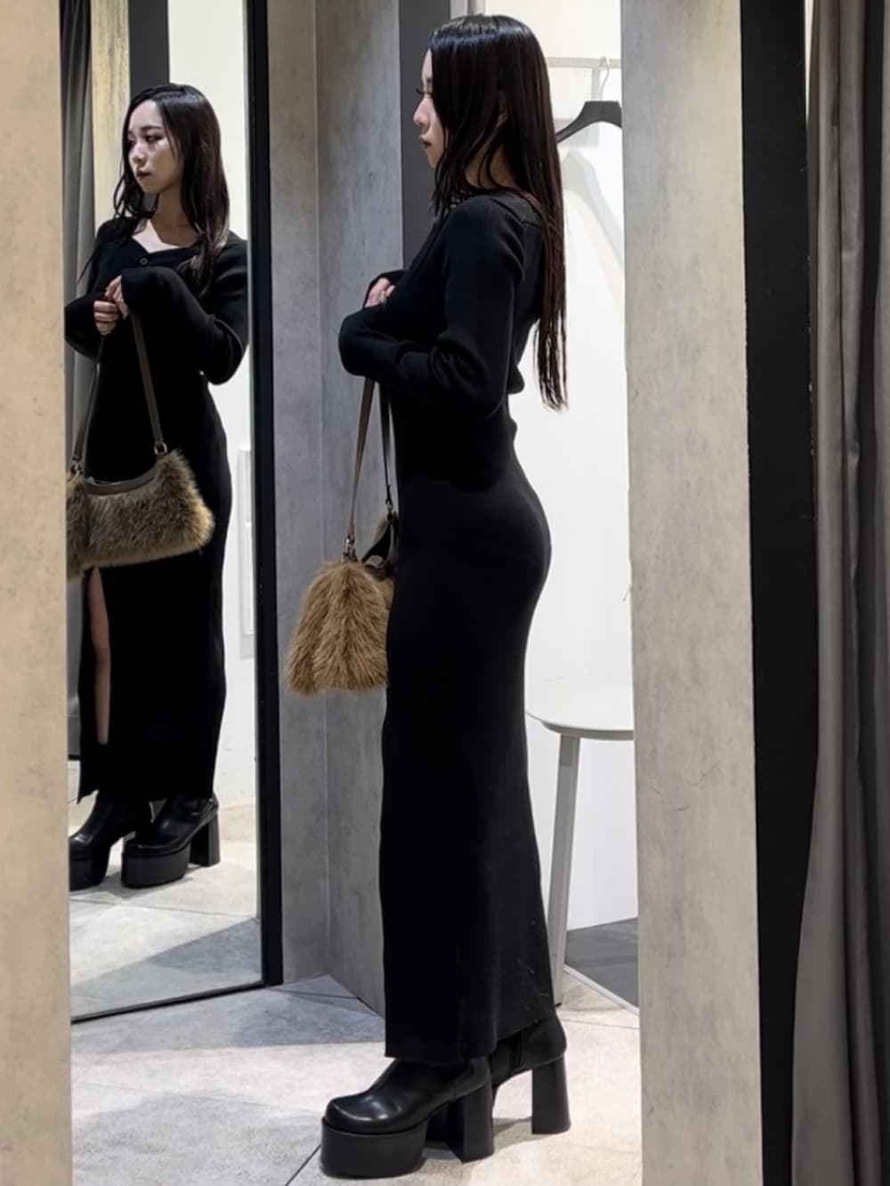 ブラック系のワンピース、ベージュ系のショルダーバッグ、ブラック系のブーツを着用したレディースの冬コーディネートの10枚目の写真